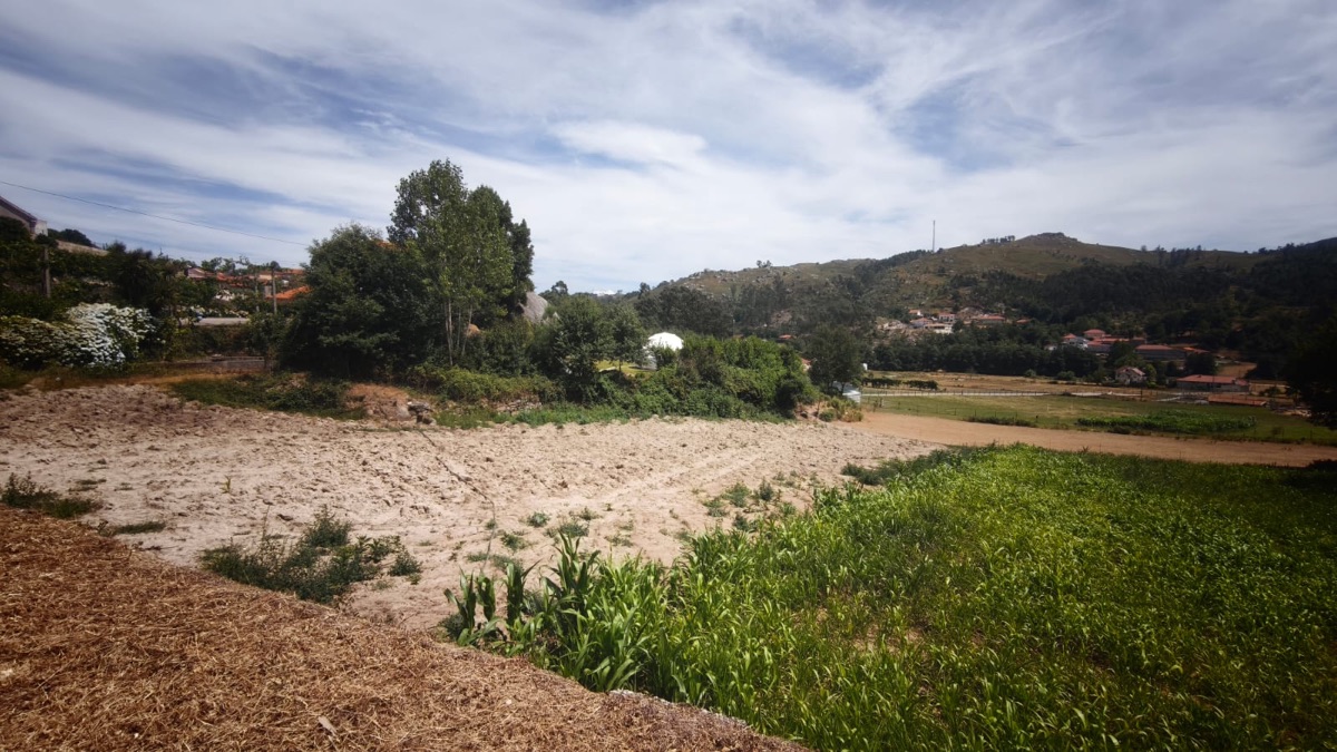 Ploughed ground on the village land, with granite houses and the hillside beyond